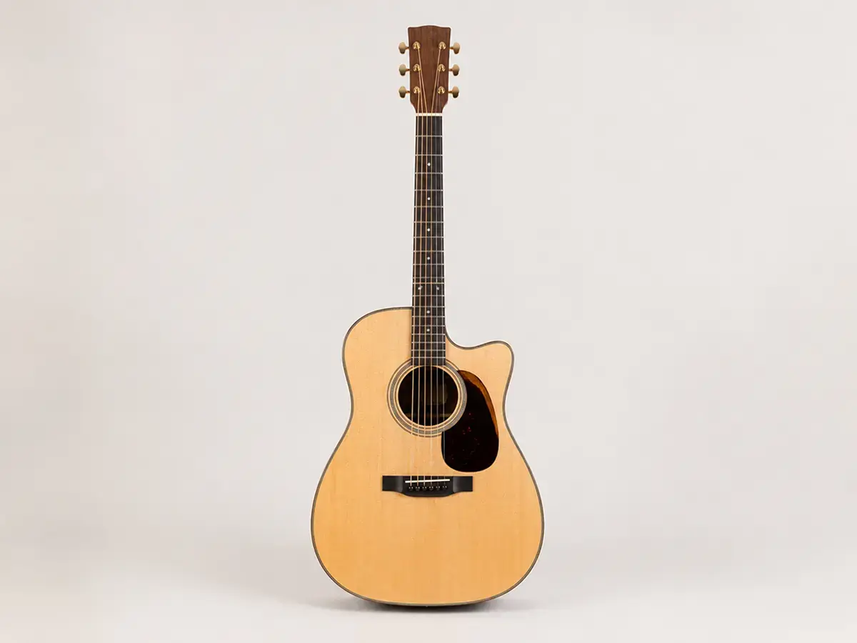 Full body shot of a cutaway acoustic guitar showing the carved-out upper bout for upper-fret access