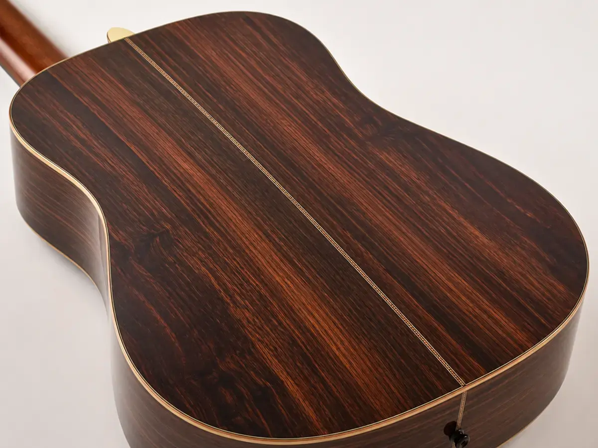 Close-up of a rosewood acoustic guitar back and sides showing its dark, richly figured grain
